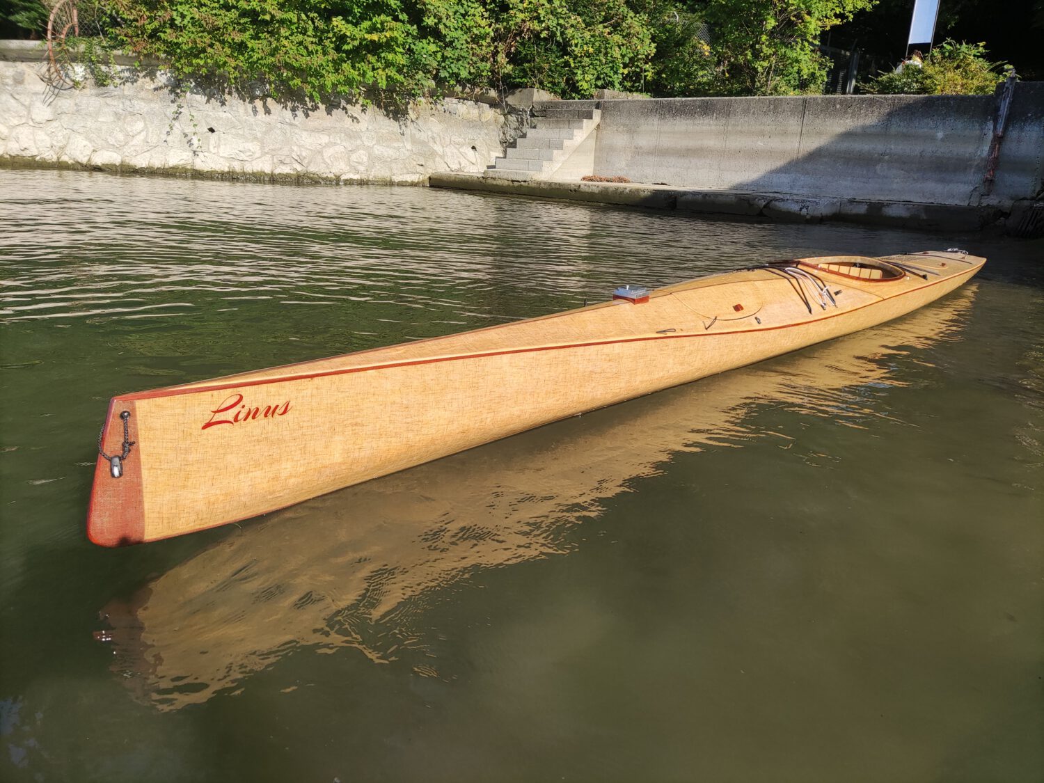 Holzkajak Linus im Wasser, gefertigt aus Weißtanne mit Bioleinen-Beschichtung, kombiniert Umweltbewusstsein mit Paddelspaß.